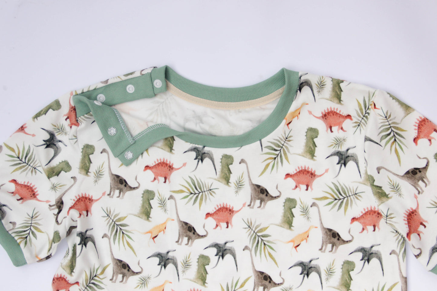 ABDL adult onesie with dinosaur design, soft cotton fabric and shoulder snaps detail