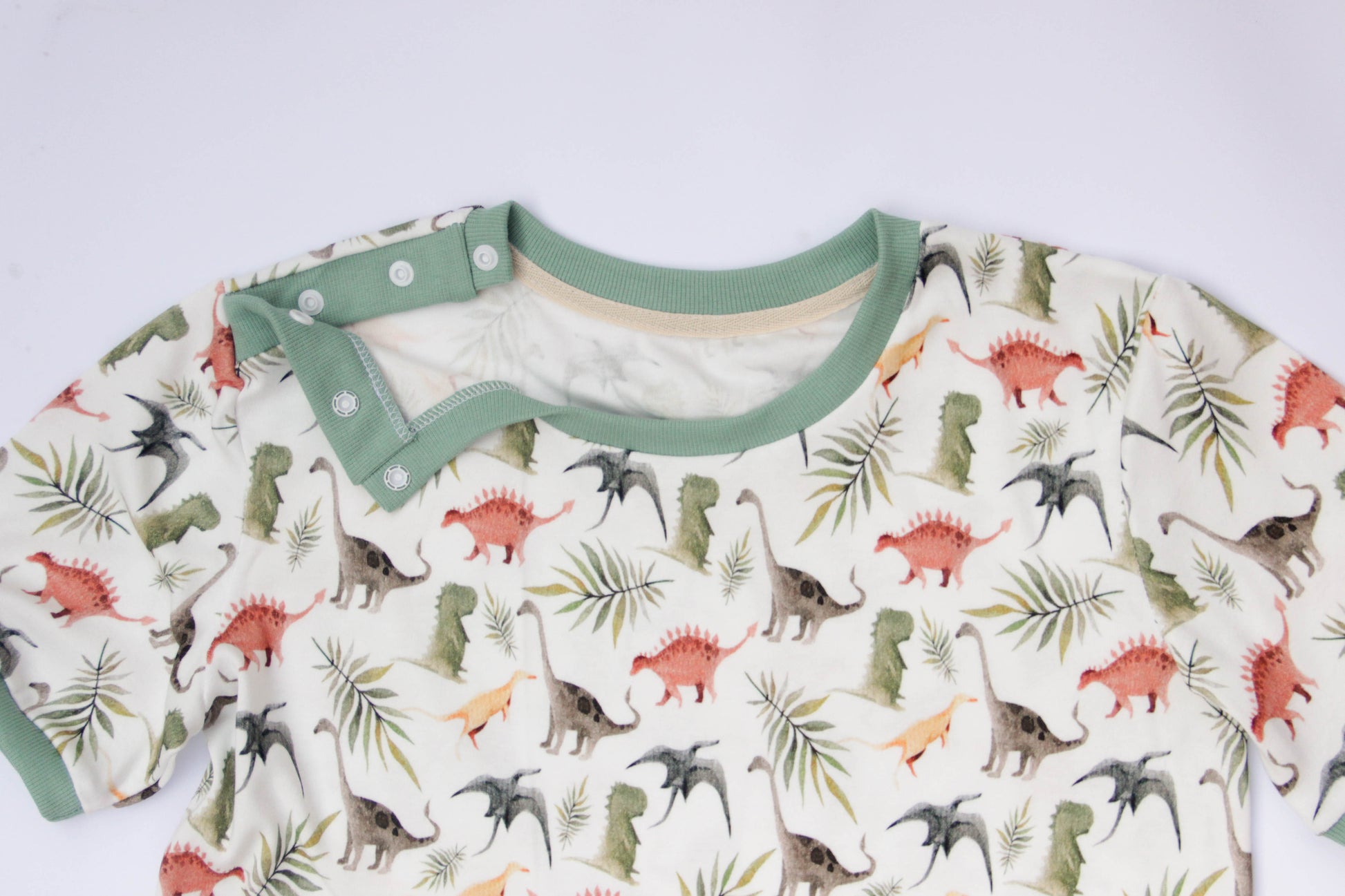 ABDL adult onesie with dinosaur design, soft cotton fabric and shoulder snaps detail