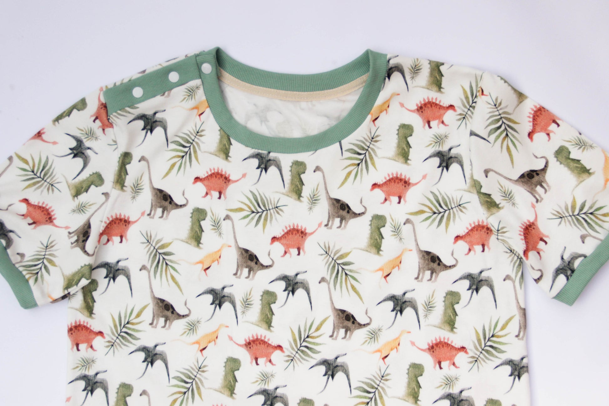 Adult baby dinosaur bodysuit showing snap buttons and comfortable diaper-friendly fit