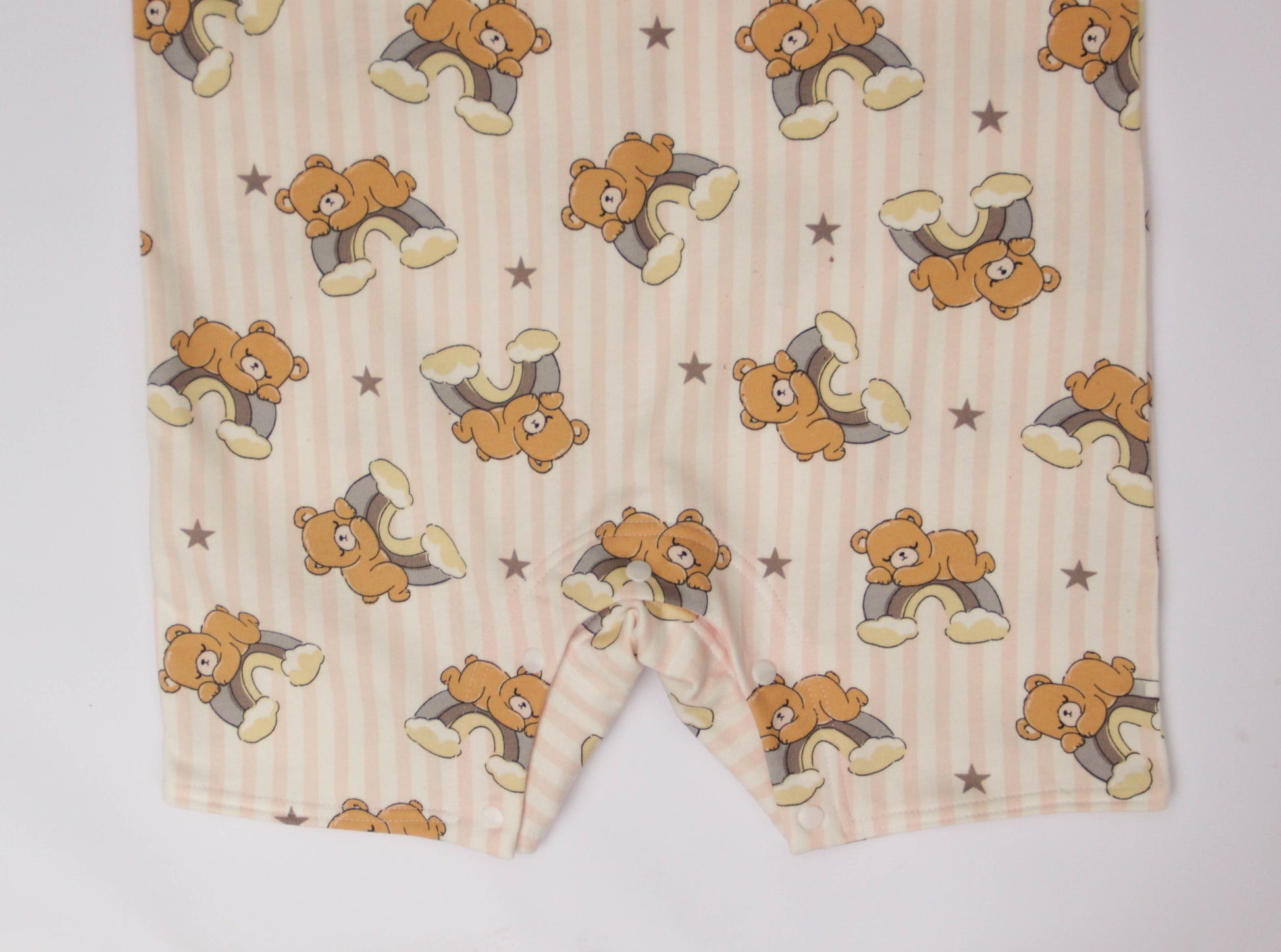 Close-up of cotton blend fabric with cute bear and rainbow print on adult baby romper, soft and stretchy material