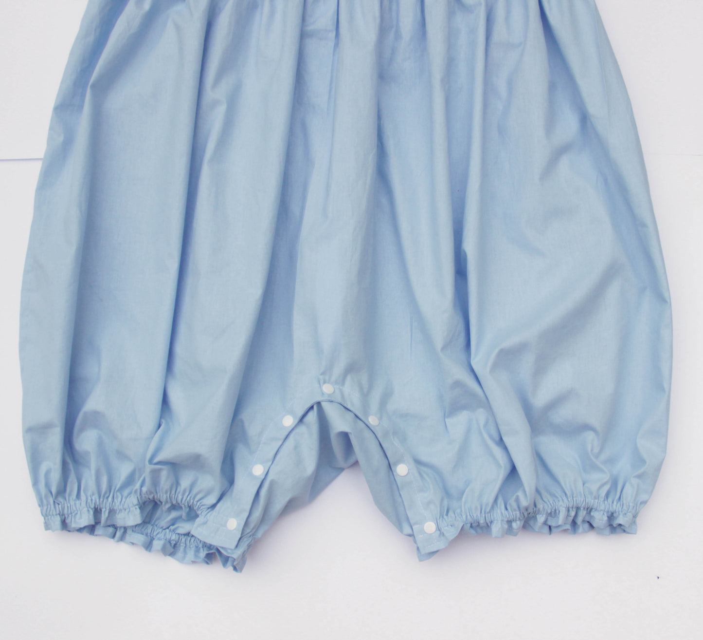 Light blue baby bloomers on a white background
